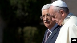 FILE - Pope Francis is welcomed by Palestinian President Mahmoud Abbas upon his arrival to the West Bank city of Bethlehem, May 25, 2014. The Vatican officially recognized the state of Palestine in a new treaty finalized.