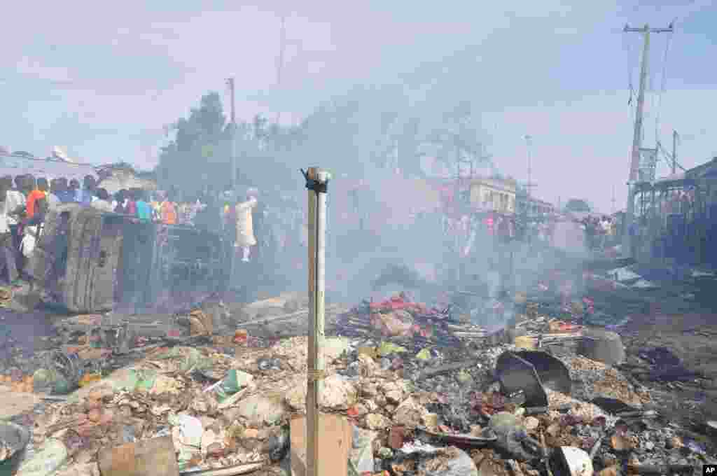 People gather at the scene of a car bomb explosion at the central market, Maiduguri, Nigeria, July 1, 2014.