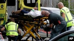 Personal médico transportan a un hombre desde frente a una mezquita en Christchurch, Nueva Zelanda, el vieres, 15 de marzo de 2019, después que decenas de personas murieran en ataques a dos mezquitas.