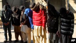 FILE - Pakistani suspects allegedly associated with the Islamic State group wait to appear in an anti-terrorism court in Gujranwala, Pakistan, Dec. 29, 2015.