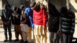 FILE - Pakistani suspects allegedly associated with the Islamic State group, wait to appear in an anti-terrorism court in Gujranwala, Pakistan, Dec. 29, 2015.