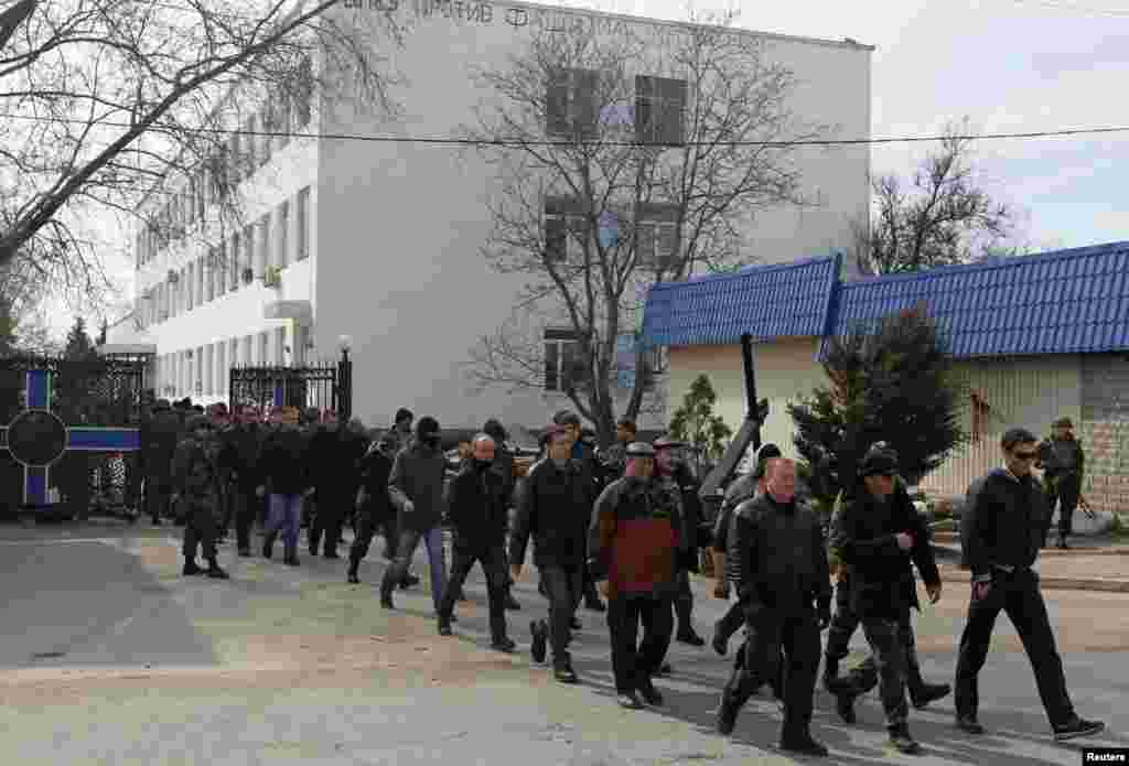 Para anggota unit pertahanan diri Krimea berbaris saat meninggalkan markas angkatan laut di Sevastopol, Krimea (19/3).