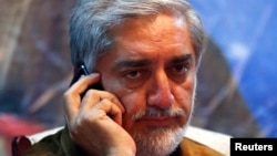 Afghan presidential candidate Abdullah Abdullah talks on his phone during an election campaign after a bomb attack on his convoy in Kabul, June 6, 2014.