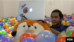 Farishki Vidyan, pekerja magang di Mozilla, bekerja sambil bersantai di ball pit di Mozilla Silicon Valley (VOA/Vina).