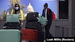 L'économiste sud-soudanais Peter Biar Ajak et sa femme arrivent à l'aéroport international de Dulles aux États-Unis, après avoir fui avec leur famille vers les États-Unis, le 23 juillet 2020. REUTERS/Leah Millis