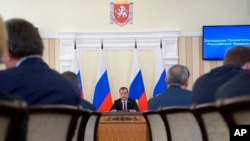Russian Prime Minister Dmitry Medvedev, center, speaks at a meeting on the economic development of Crimea in Simferopol, Crimea, March 31, 2014.