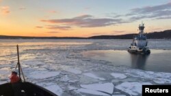 U.S. Coast Guard Cutter Penobscot Bay helps break free tug Stephanie Dann from the ice on the Hudson River near Kingston, New York, U.S. Photo/Handout via REUTERS