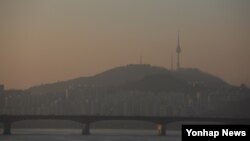 중국발 스모그의 유입으로 미세먼지 농도가 높게 나타난 23일 오후 해가 내려앉자 서울하늘을 뒤덮고 있던 먼지층이 붉게 보이고 있다.