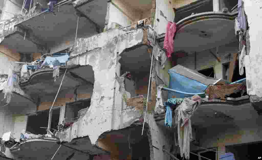 一个男人站在一间被毁坏的公寓里。它是2013年3月4日被一个汽车炸弹爆炸损毁的。爆炸导致数十人丧生。