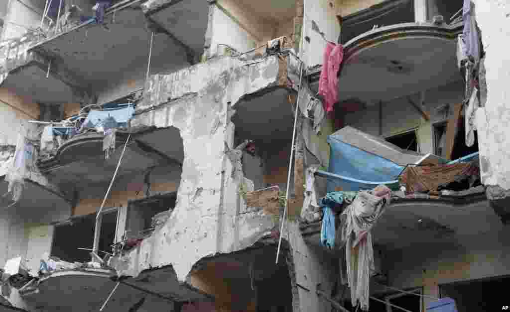 A man stands in an apartment that was damaged in a car bombing that killed scores of people, in Karachi, Pakistan, March 4, 2013.