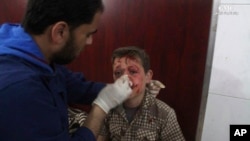 This photo provided by the Syrian anti-government activist group Ghouta Media Center, which has been authenticated based on its contents and other AP reporting, shows a Syrian doctor treating a boy who was wounded by Syrian government forces shelling, at a makeshift hospital in the Hamouriyya neighborhood, an eastern suburb of Damascus, Syria, May 16, 2017. 