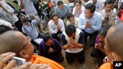 Cambodia National Rescue Party's commune chief Sieng Chet, center, is blessed by Buddhist monks outside the main prison gate of Prey Sar on the outskirts of Phnom Penh, Cambodia, Thursday, Dec. 8, 2016. Sieng Chet was released Thursday from the prison after he was convicted to five years on accusations he tried to help cover up a woman's affair with the party's deputy leader. (AP Photo/Heng Sinith)