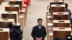 Lin Zuluan holds his ballot before casting during an election to select village committees in which he was elected to village chief in Wukan, Lufeng city, south China's Guangdong province, March 3, 2012.