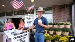 John G. Gauthiere collects signatures outside a grocery store in Greeley, Colorado. (AP Photo/David Zalubowski)