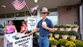John G. Gauthiere collects signatures outside a grocery store in Greeley, Colorado. (AP Photo/David Zalubowski)