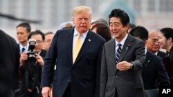 Presiden AS Donald Trump (tengah) bersama PM Jepang Shinzo Abe, meninggalkan kapal tempur Jepang "JS Kaga", usai lawatannya di Yokosuka, selatan Tokyo, Selasa, 28 Mei 2019.
