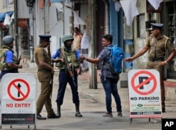 Policías de Sri Lanka verifican la tarjeta de identidad de una persona que lleva una mochila en Colombo, Sri Lanka, el lunes 29 de abril de 2019. La Iglesia católica en Sri Lanka dice que el gobierno debería reprimir a los extremistas islámicos con más vigor "como si estuviera en guerra..."