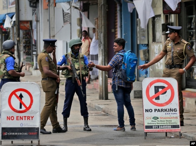 Policías de Sri Lanka verifican la tarjeta de identidad de una persona que lleva una mochila en Colombo, Sri Lanka, el lunes 29 de abril de 2019. La Iglesia católica en Sri Lanka dice que el gobierno debería reprimir a los extremistas islámicos con más vigor "como si estuviera en guerra..."