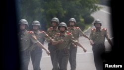 DMZ 지뢰 폭발사고로 남북간 긴장이 고조된 지난 2015년 8월, 철모를 쓴 북한 군인들이 판문점 주변을 순찰하고 있다. (자료사진)
