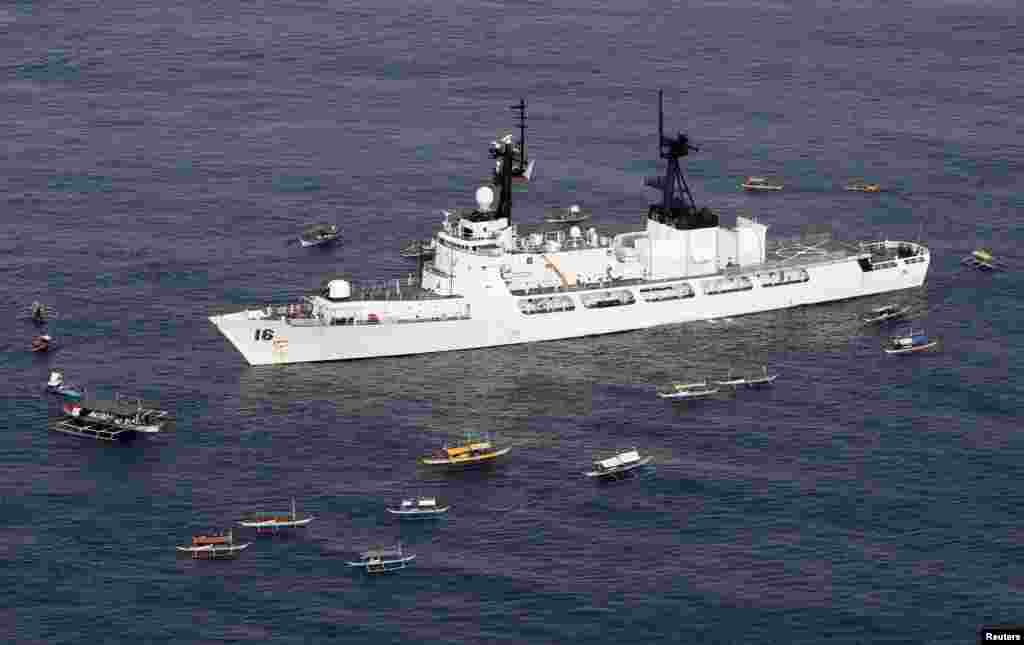 Ngư dân Philippines và tàu chiến tuần tra của hải quân đón chào tàu BRP Ramon Alcaraz ở biển Casiguran, bắc Philippines, 2 tháng 8, 2013.