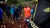 FILE - an athlete sets the timer on his watch before starting to run with others in Kaptagat Forest in western Kenya. 