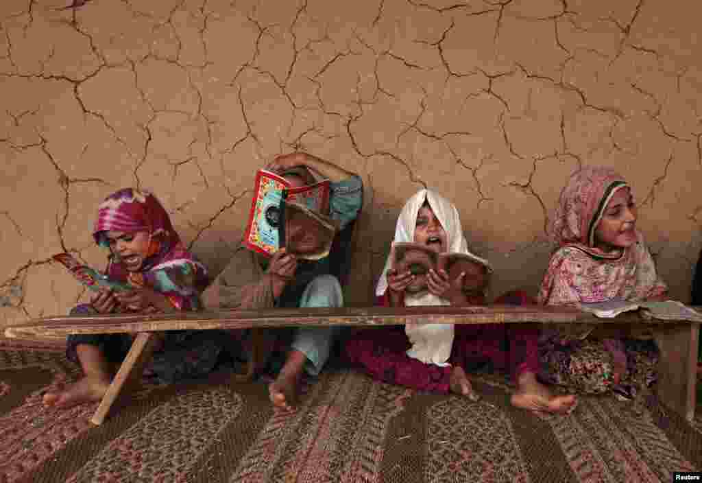 Girls read books containing short verses from the Koran in a madrasa, or religious school, on the outskirts of Islamabad, Pakistan.