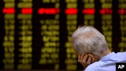 A Chinese investor monitors stock prices at a brokerage house in Beijing, Sept. 15, 2015.