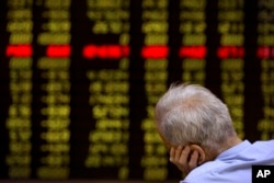 A Chinese investor monitors stock prices at a brokerage house in Beijing, Sept. 15, 2015.