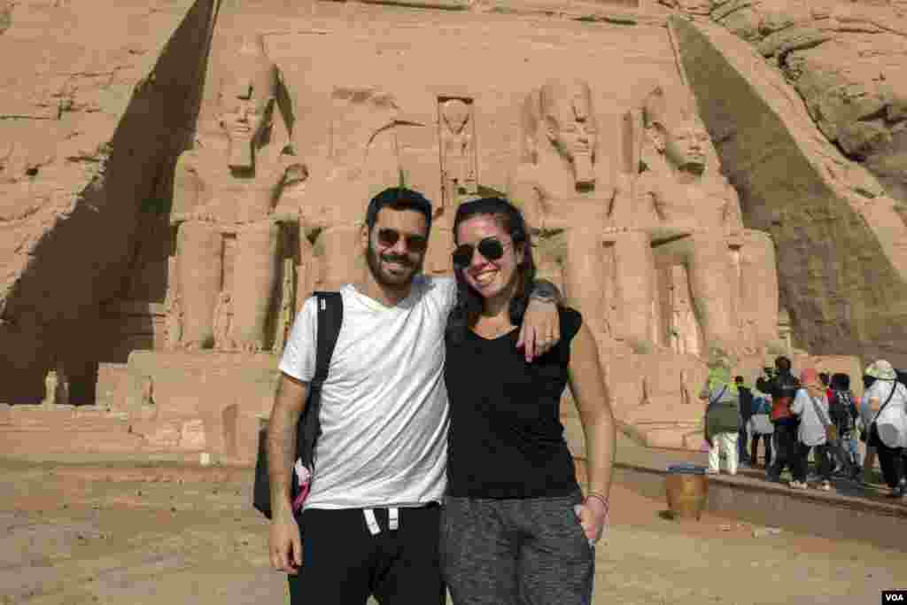 Warga Mesir Fady Abadir dan istrinya warga Amerika Serikat, Melis Bursin,&nbsp; yang menikmati pengalaman mereka. &ldquo;Ini pertama kalinya saya berada di Mesir,&quot; kata Bursin. &quot;Seperti mimpi rasanya.&rdquo; Kuil Abu Simbel di Aswan, selatan Mesir, 22 Februari 2018. (H. Elrasam/VOA)