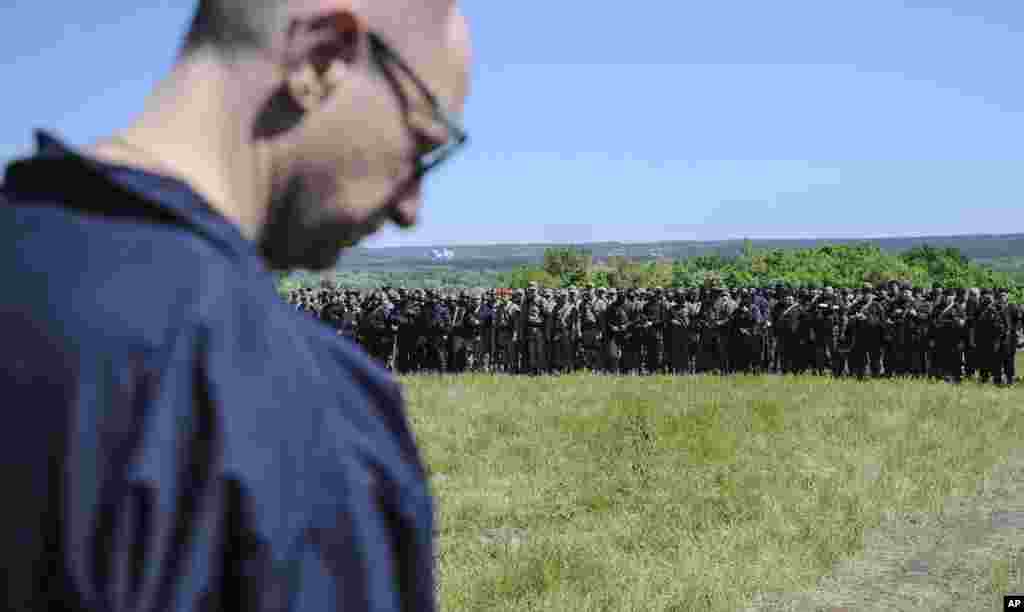 Ukrainian Prime Minister Arseniy Yatsenyuk stands in front of Ukrainian soldiers at a block post on the road at Slovyansk, Ukraine, Wednesday, May 7, 2014. Ukrainian military operations that began Monday to expunge pro-Russia forces from the city of Slovyansk were the interim government&#39;s most ambitious effort so far to quell weeks of unrest in Ukraine&#39;s mainly Russian-speaking east. (AP Photo/Andrew Kravchenko, Pool)
