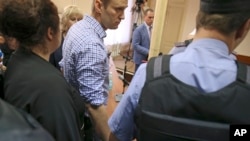 Alexei Navalny es esposado por la policía tras anunciarse la condena. 