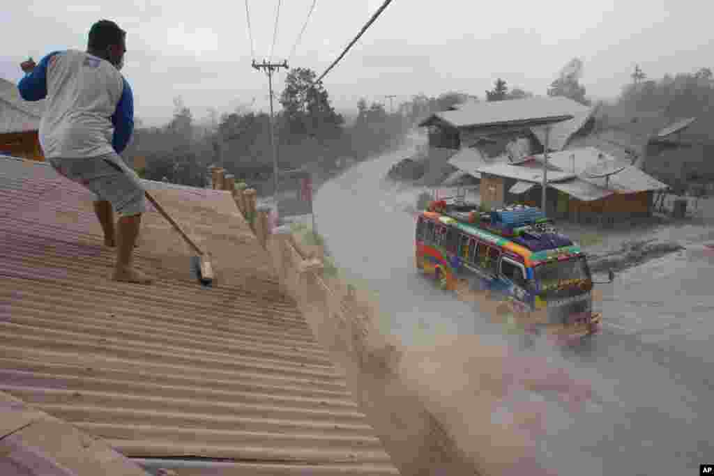 Một người đàn ông quét tro núi lửa trên mái nhà sau khi núi lửa Sinabung tại Sibintun, Bắc Sumatra, Indonesia hoạt động trở lại. Núi lửa bắt đầu phun tro bụi kể từ tháng 9 năm ngoái, làm hơn 20.000 người sống chung quanh sườn núi phải sơ tán đến một vài trại tạm trú.