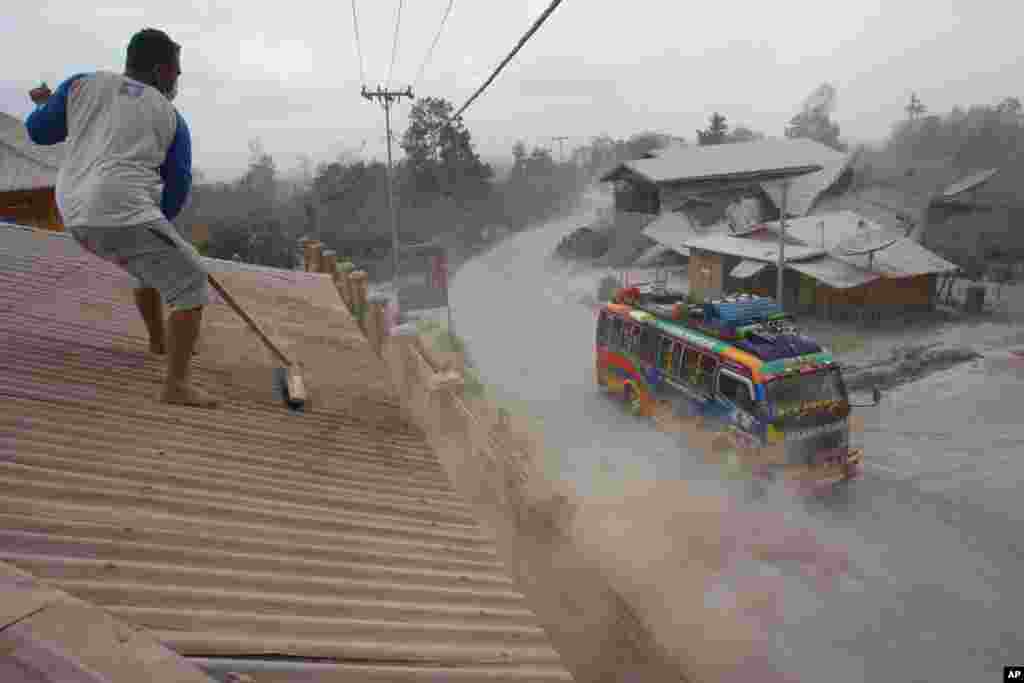 A man sweeps volcanic ash from the roof of a house following an ash fall from the eruption of Mt. Sinabung in Sibintun, North Sumatra, Indonesia. The volcano has been erupting since September, forcing more than 20,000 people who live around its slopes to flee their homes to several temporary shelters. 