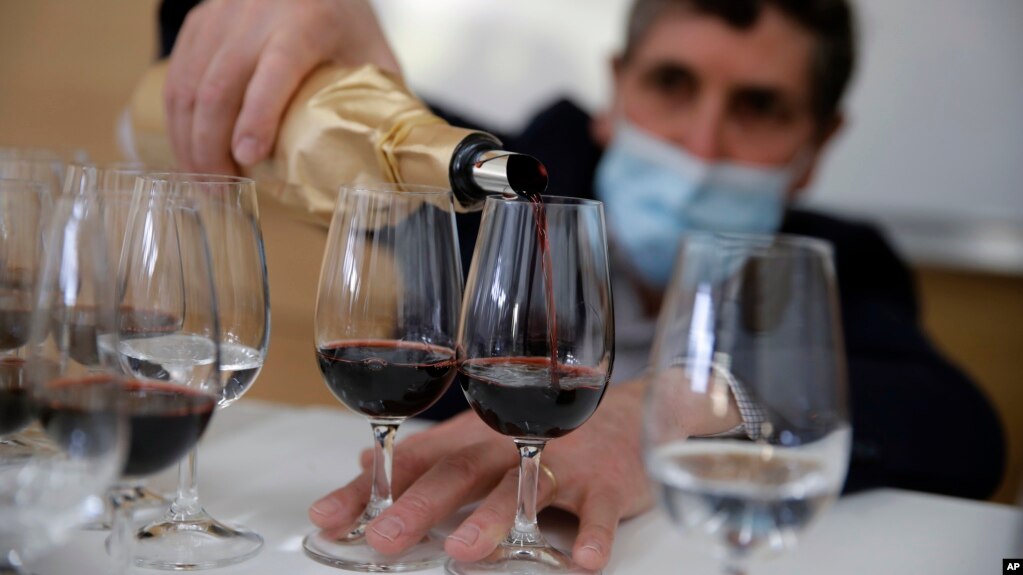 Philippe Darriet, Président of the Institute for wine and vine research and head oenologist fills glasses with wine for a blind tasting at the ISVV Institue in Villenave-d'Ornon, southwestern France, Monday, March 1, 2021. 