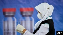 Seorang petugas kesehatan menyiapkan vaksin COVID-19 Sinovac untuk vaksinasi massal di gedung convention hall Banda Aceh, 7 Juni 2021. (Foto: CHAIDEER MAHYUDDIN/AFP)