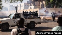 Security forces drive towards protestors to fire tear gas during a demonstration in Ouagadougou on Nov. 27, 2021.