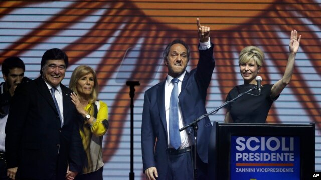 El gobernador de Buenos Aires y candidato oficialista a la presidencia de Argentina, Daniel Scioli, y su esposa Karina Rabolini, saludan a sus partidarios en el cierre de campaña, el jueves, 22 de octubre de 2015.