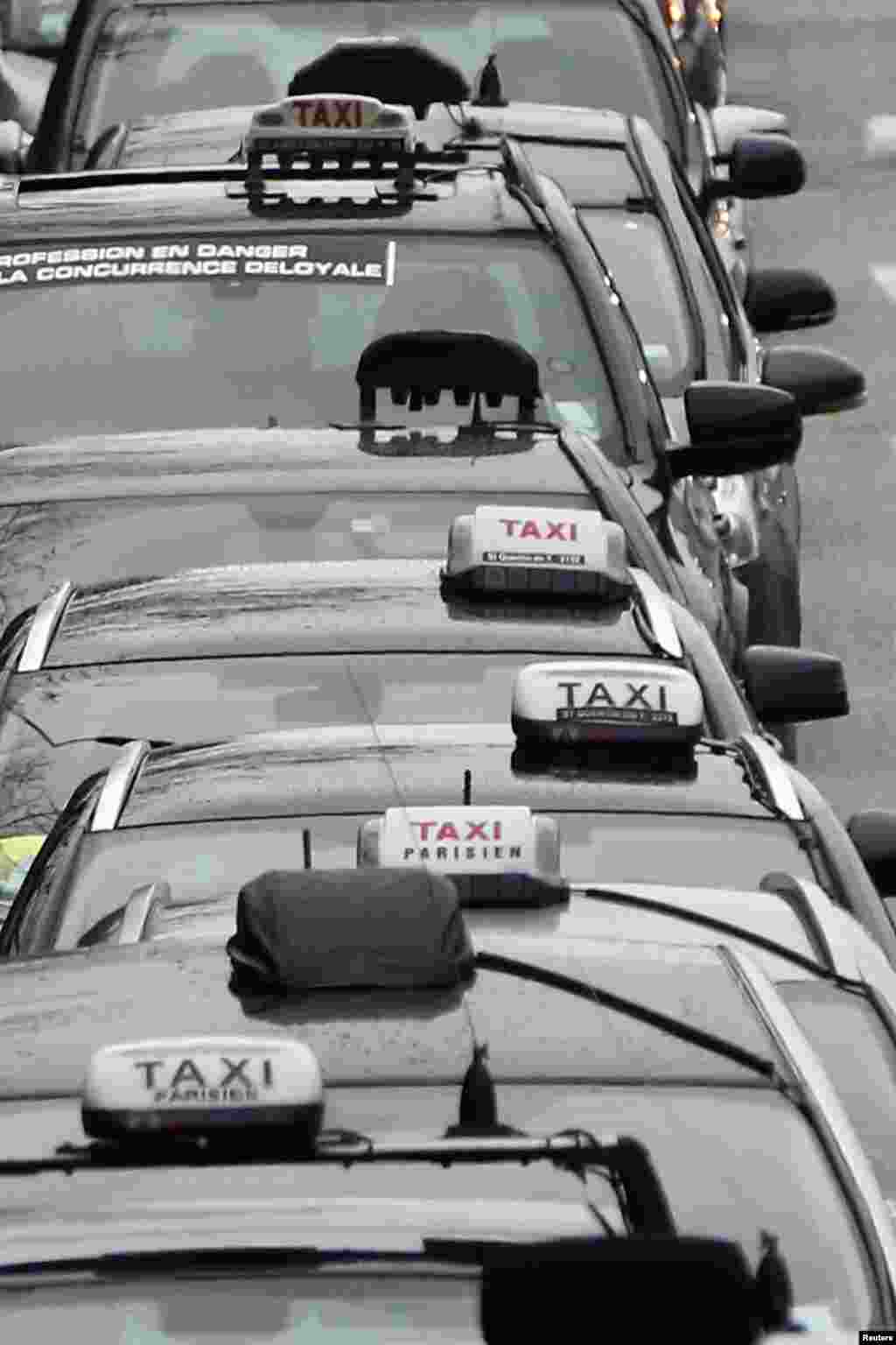 Striking Paris taxis slow traffic in a demonstration over the Paris ring road, Dec. 15, 2014.