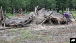 FILE: A young boy shows a hut that was destroyed by floods in Tsholostho, about 200 kilometers north of Bulawayo, March 4, 2017.