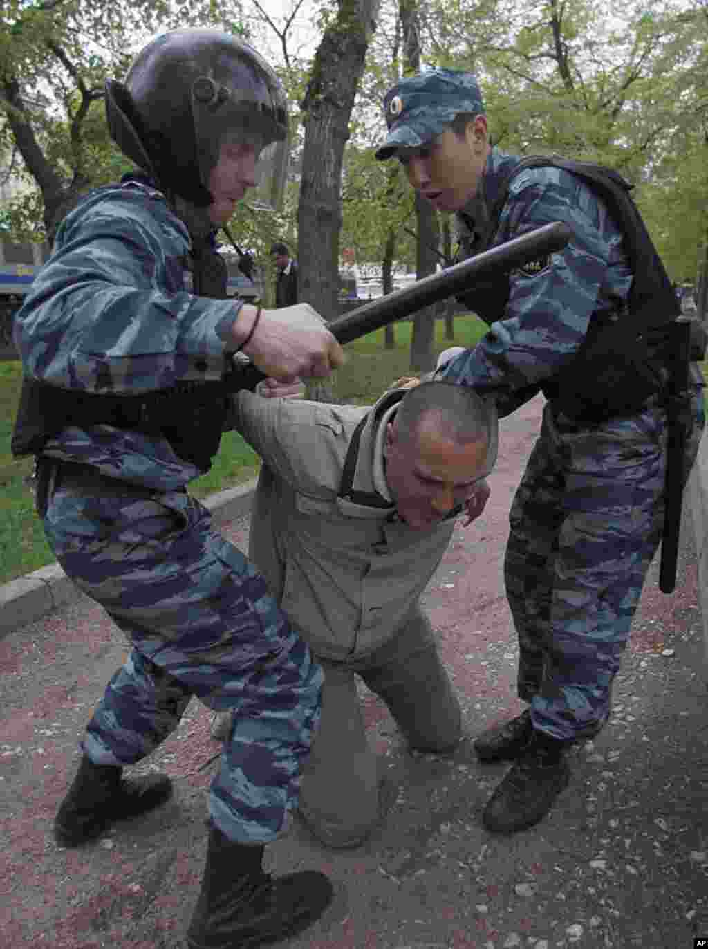 Members from Russia's Interior Ministry detain an opposition supporter during an unsanctioned protest. (Reuters)