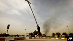 Black smoke from a car bomb attack is seen from the the Crossed Swords monument in Baghad, Iraq, March, 14, 2013.
