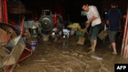 Cư dân ở miền Nam Đài Loan cạo bùn ra khỏi nhà cửa sau trận lũ lụt và đất lở gây ra bởi cơn bão Nanmadol, ngày 29/8/2011