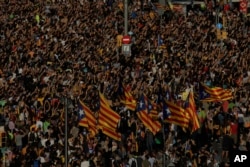 Protesters with ''esteladas'' or Catalonia independence flags pack the University square during a one-day strike in Barcelona, Spain, Tuesday Oct. 3, 2017. Labor unions and grassroots pro-independence groups are urging workers to hold partial or full-day strikes throughout Catalonia to protest alleged brutality by police during a referendum on the region's secession from Spain that left hundreds of people injured.