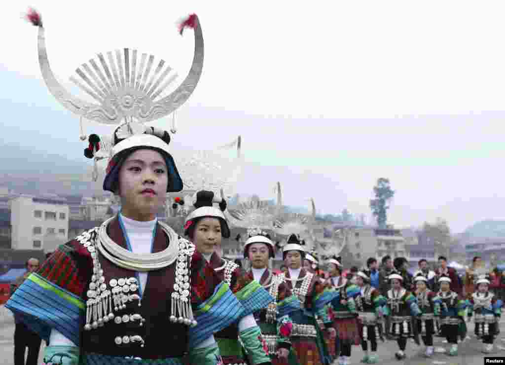 Women and girls wearing Miao traditional costumes dance during the traditional Lusheng (reed-pipe wind instrument) Festival in Kaili, Guizhou province, March 10, 2015.