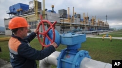 FILE - A worker at a Ukrainian gas station in Volovets, western Ukraine controls a valve on Oct. 7, 2015. 