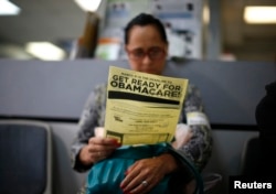 FILE - A woman reads a leaflet on Obamacare at a health insurance enrollment event in Cudahy, California, March 27, 2014. The initiative, launched in 2010 and long scorned by Republicans, has been providing health care coverage to some 20 million previously uninsured Americans.