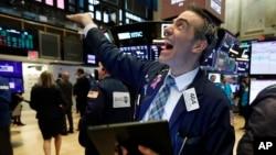 Trader Gregory Rowe reacts with fellow traders as he works on the floor of the New York Stock Exchange, May 1, 2019.