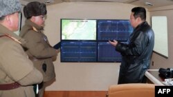 金正恩在观看导弹试射期间与官员谈话。（2022年1月11日）