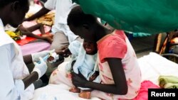 FILE - A medical worker attends to a malnourished child at a Medecins Sans Frontieres hospital in a displaced-persons camp inside the U.N. base in Malakal, South Sudan, July 24, 2014. 