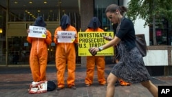 Miembros de Amnistía Internacional protestan en las afueras del edificio donde el vicepresidente Dick Cheney defendía los métodos de interrogación empleados por la CIA.